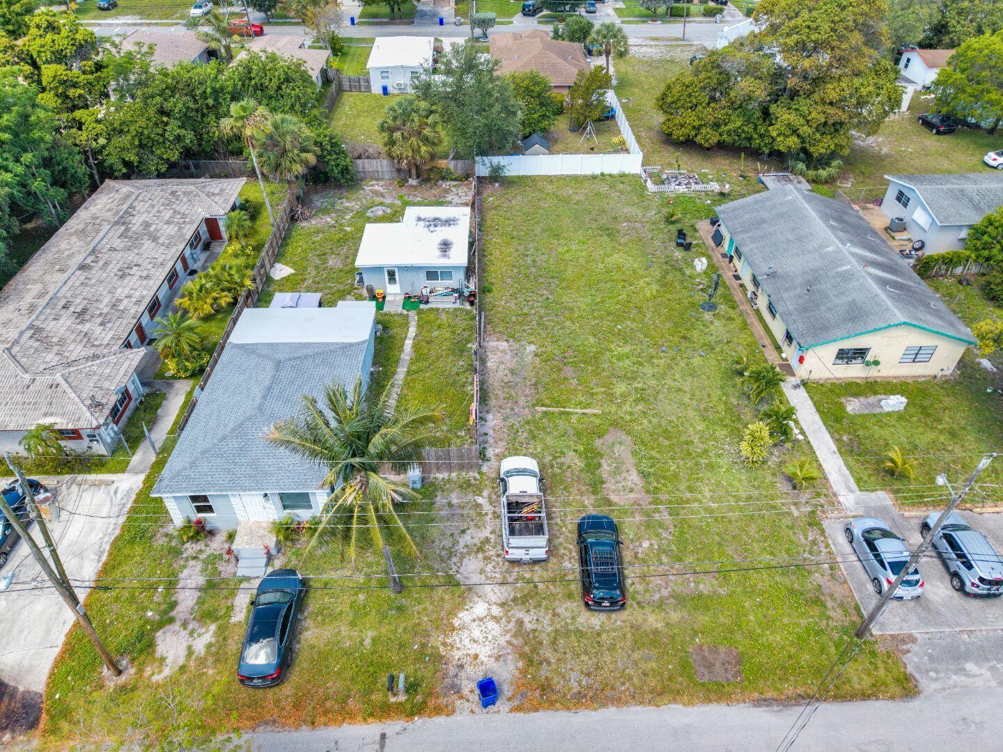 An aerial view shows a vacant lot situated between two residential houses with parked vehicles — 625 NW 15th Avenue, Pompano Beach FL 33069, POMPANO BEACH, FL