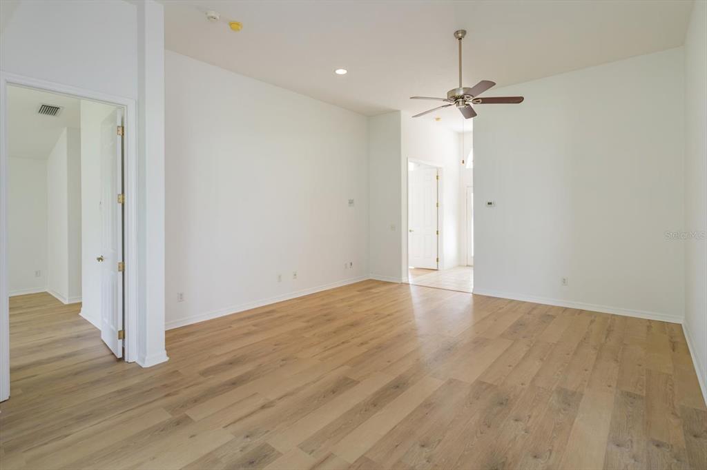 An empty room features light wood-look flooring, white walls, and a ceiling fan — 931 VINDALE ROAD, TAVARES, FL