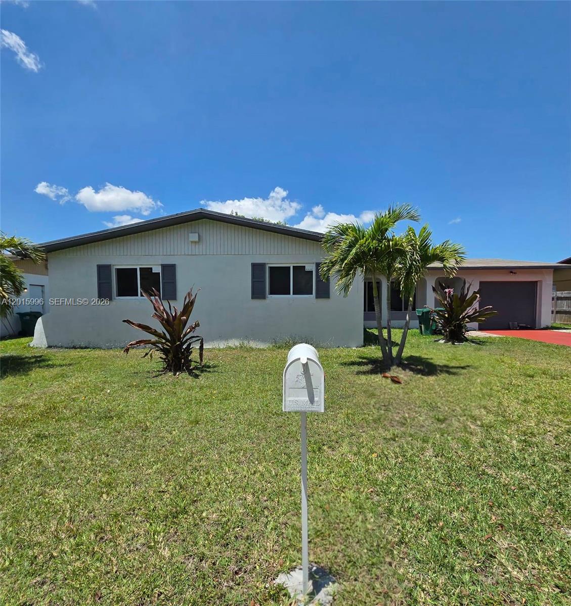 A single-story house with a light-colored facade, dark shutters, and a front yard lawn — 11941 SW 200th St, Miami FL 33177, MIAMI, FL