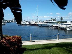 A view of a marina with several boats docked along a concrete pier and grass — 2600 HARBOURSIDE DRIVE UNIT B-16, LONGBOAT KEY, FL