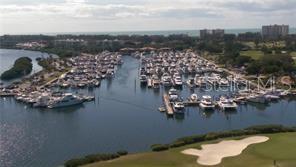 An aerial view shows a large marina filled with boats next to a golf course — 2600 HARBOURSIDE DRIVE UNIT B-16, LONGBOAT KEY, FL