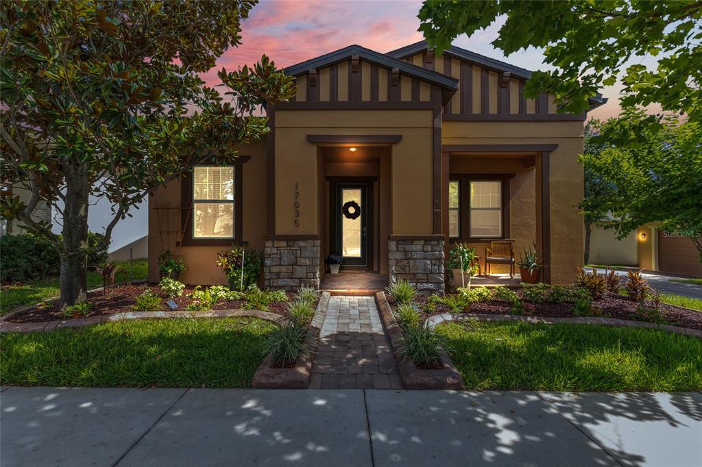 A single-story house with a stone-accented entryway, a paved walkway, and a landscaped front yard — 17035 HARBOR OAK PARKWAY, WINTER GARDEN, FL