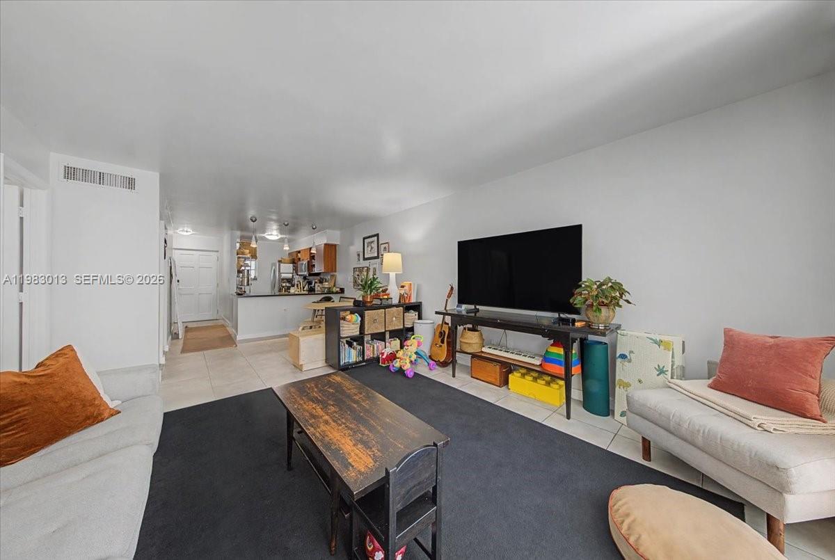 A living room features a television on a console, a coffee table, and area rug — 777 NE 62nd St # C211, Miami FL 33138, MIAMI, FL