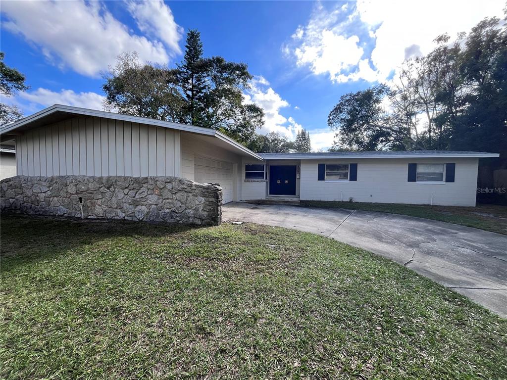 A single-story house with a stone facade, vertical siding, and a concrete driveway — 2730 PRINCE JOHN ROAD, WINTER PARK, FL