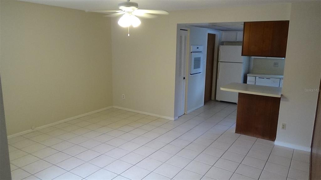 A dining area with tile flooring and a ceiling fan opens into a kitchen — 2730 PRINCE JOHN ROAD, WINTER PARK, FL