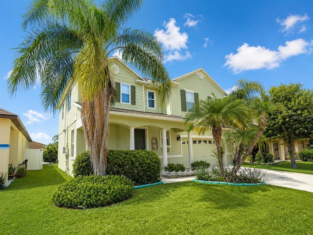 A two-story light green house with a palm tree in the front yard — 2808 PAYNES PRAIRIE CIRCLE, KISSIMMEE, FL