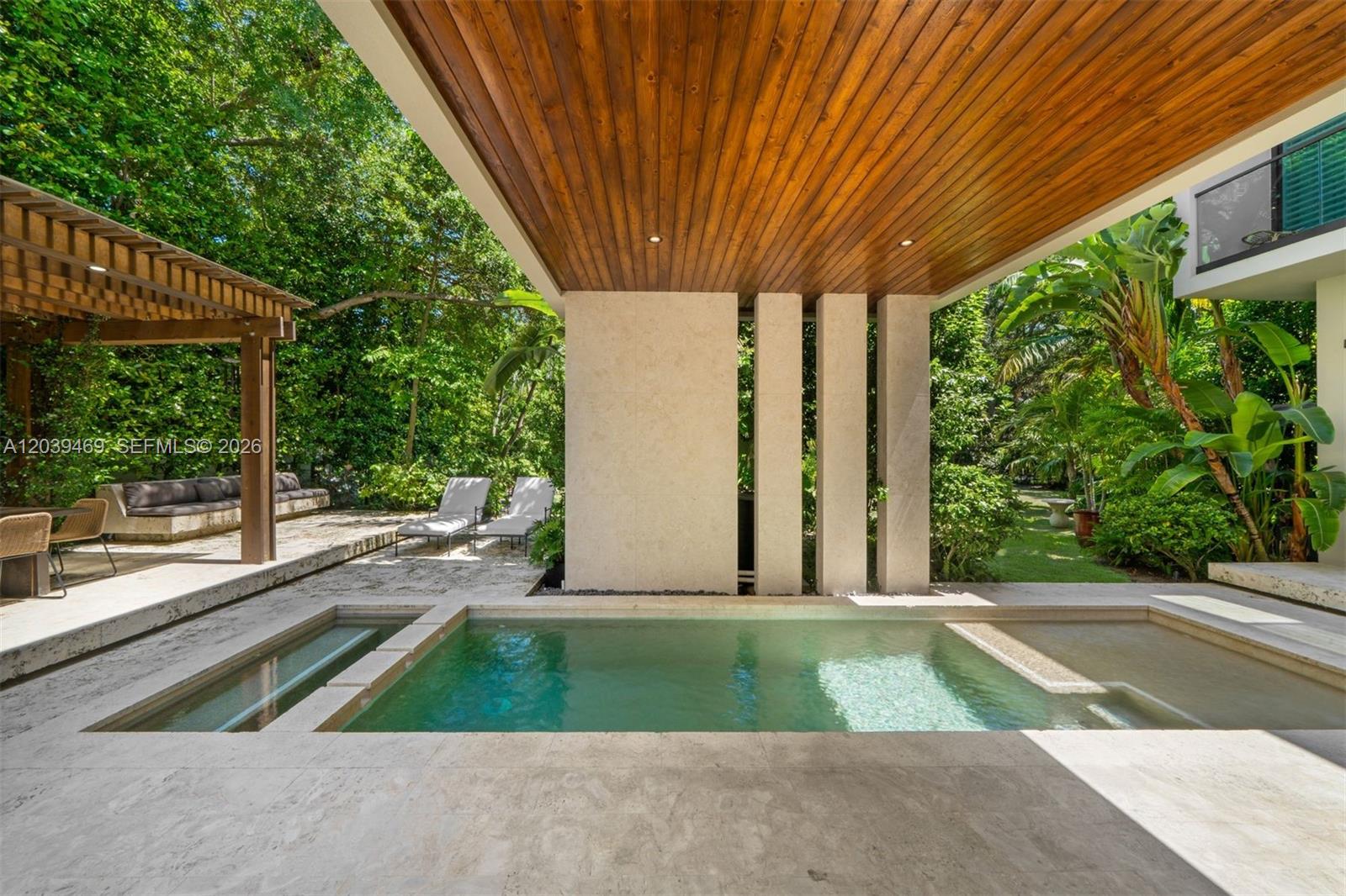 A modern outdoor patio features a swimming pool, a wooden ceiling, and lush tropical landscaping — 7851 SW 48th Pl, Miami FL 33143, MIAMI, FL