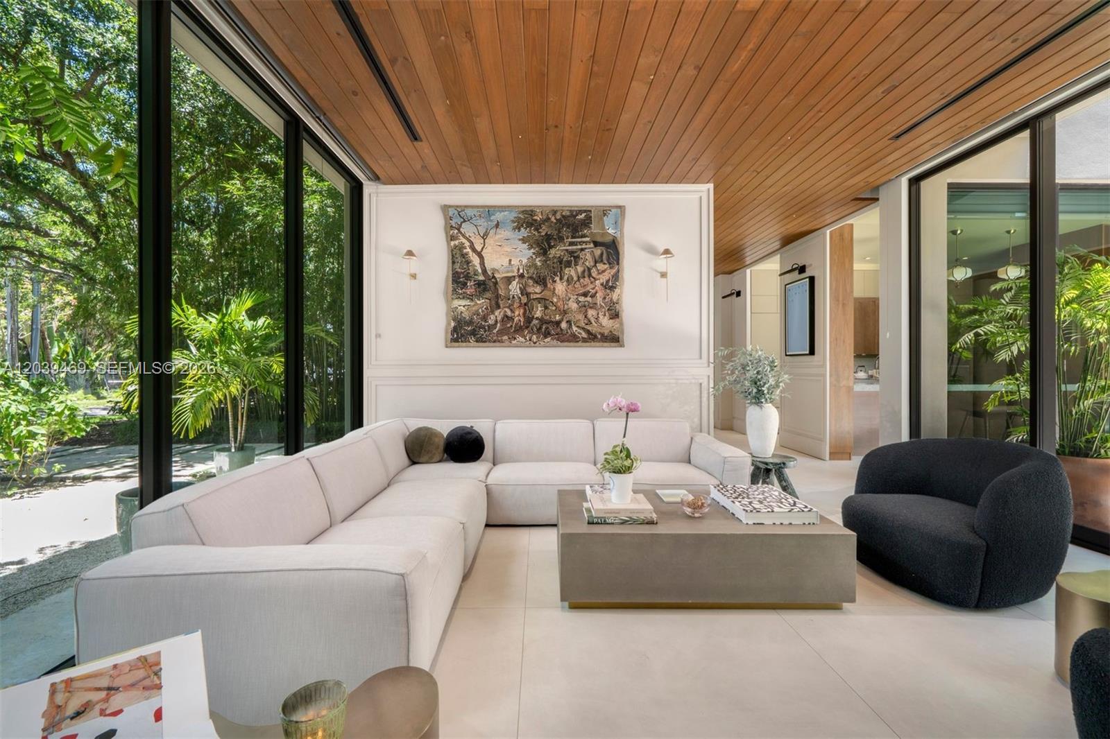 A modern living room features a large sectional sofa, concrete coffee table, and floor-to-ceiling windows — 7851 SW 48th Pl, Miami FL 33143, MIAMI, FL