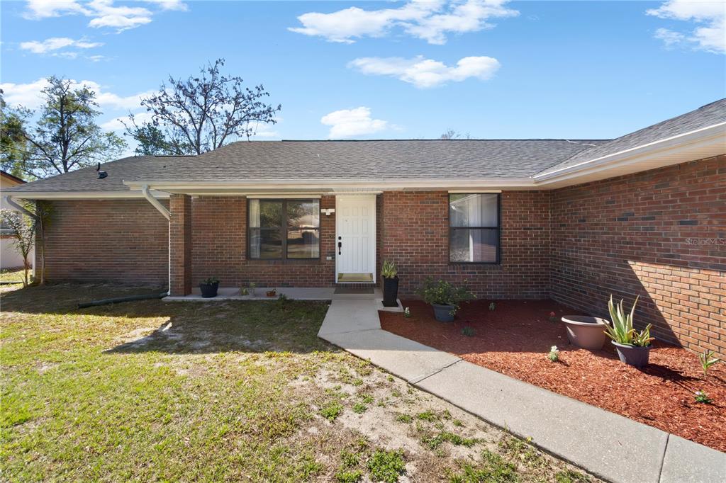 A brick-front house with a white garage door and a concrete driveway — 857 S ATMORE CIRCLE, DELTONA, FL
