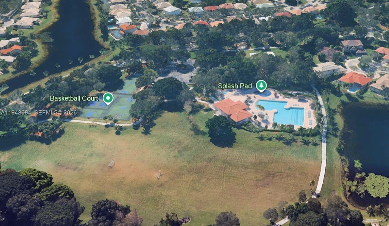 This aerial view shows a community park with a swimming pool, splash pad, and basketball court — 4023 Turnstone Ct # 4023, Weston FL 33331, WESTON, FL