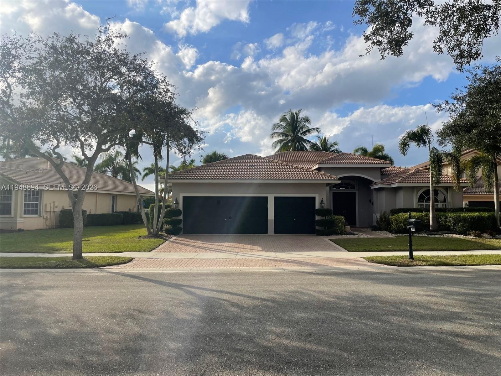 A single-story house with a tiled roof, a two-car garage, and a paved driveway — 4023 Turnstone Ct # 4023, Weston FL 33331, WESTON, FL