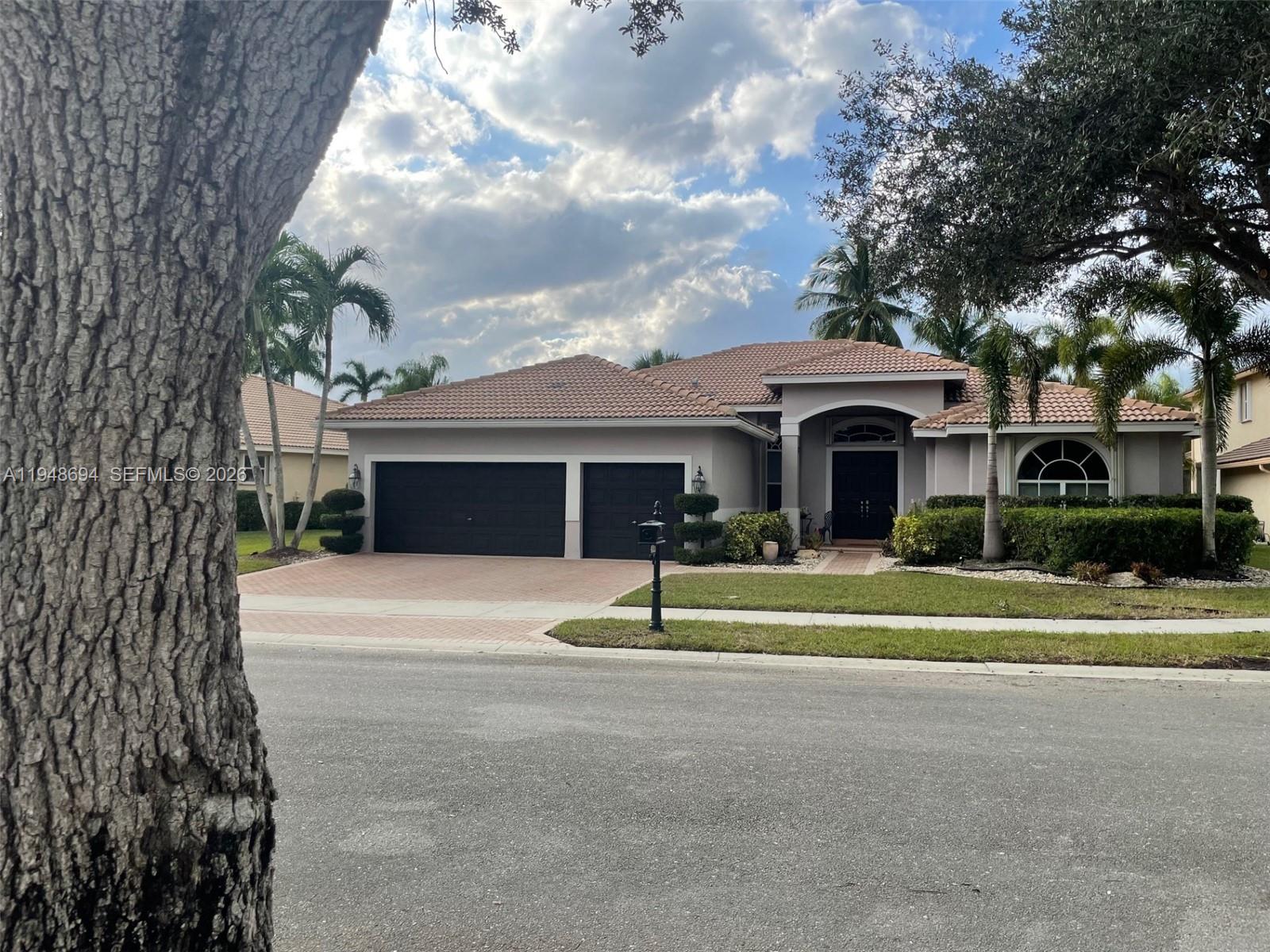 A single-story house with a tiled roof, two-car garage, and palm trees in the yard — 4023 Turnstone Ct # 4023, Weston FL 33331, WESTON, FL