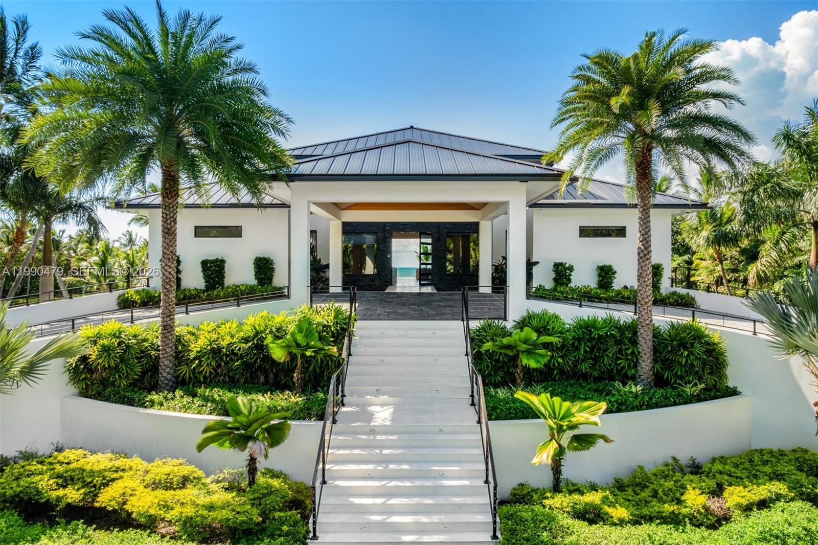 A modern white house with a metal roof features a central staircase and palm trees — 87429 Old Hwy, Islamorada FL 33036, ISLAMORADA, FL