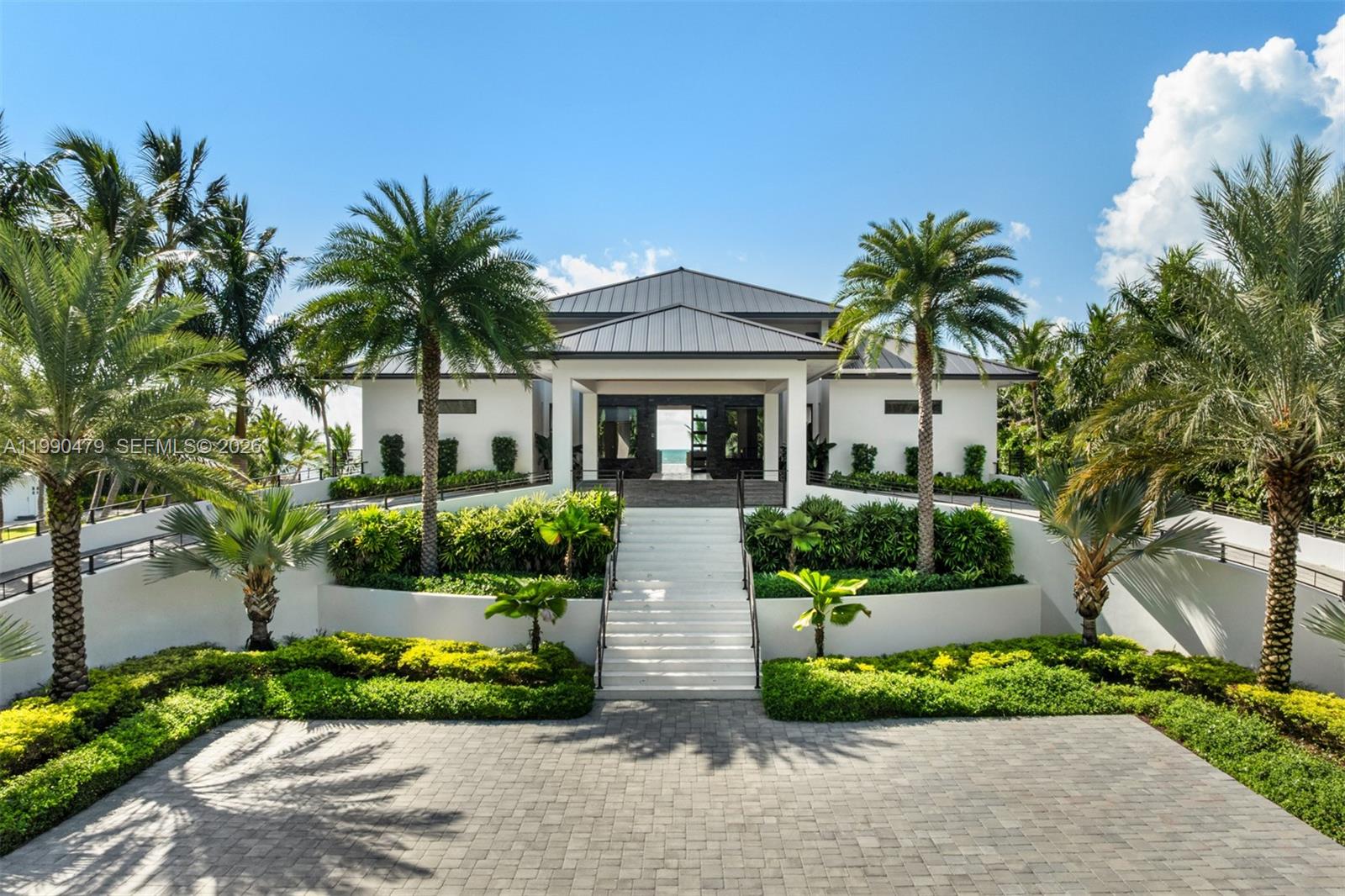 A white house with a metal roof features a central staircase leading to the entrance — 87429 Old Hwy, Islamorada FL 33036, ISLAMORADA, FL