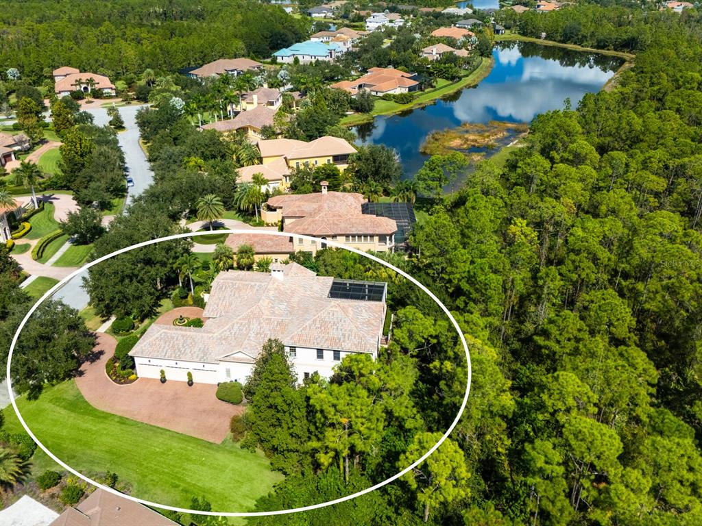 An aerial view shows a large, light-colored house with a tiled roof and circular driveway — 8309 FARINGTON COURT, BRADENTON, FL