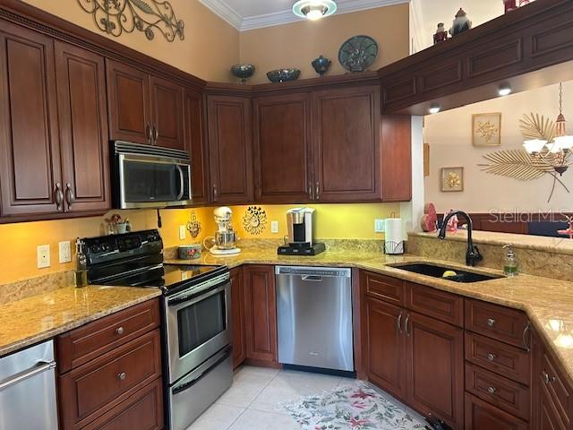 A kitchen features dark wood cabinets, granite countertops, and stainless steel appliances — 1308 LAKE WILLISARA CIRCLE UNIT 28-12, ORLANDO, FL