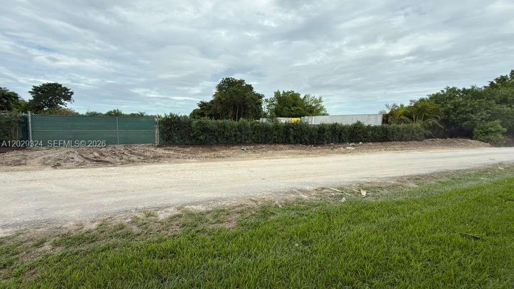 A dirt road runs in front of a fenced lot with trees and a trailer — SW 213TH AVE, Miami FL 33187, MIAMI, FL