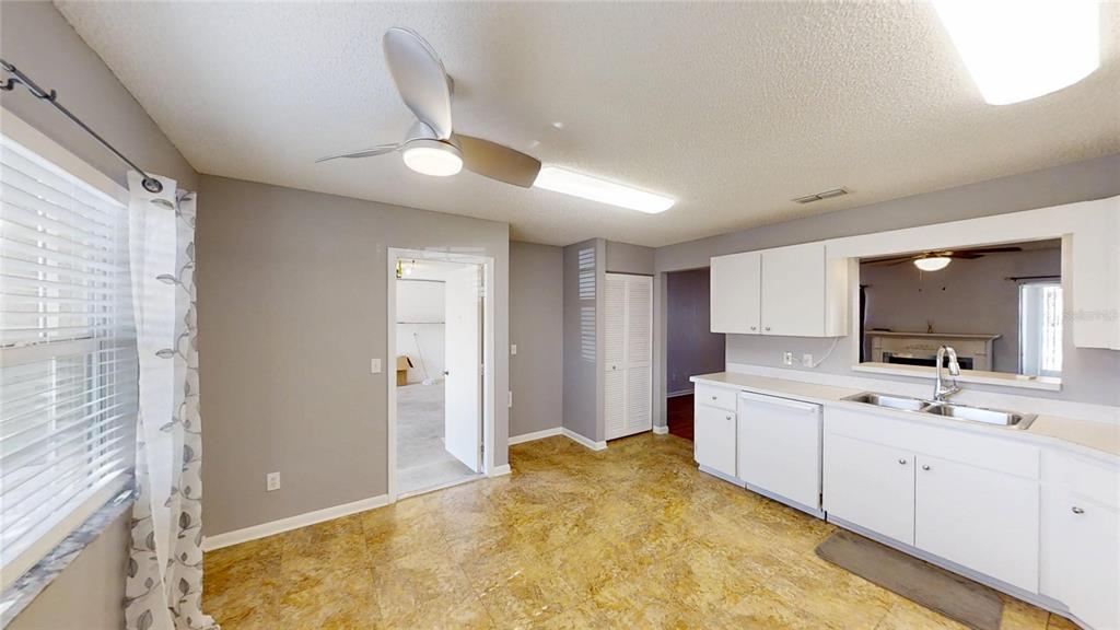 A kitchen with white cabinets, a ceiling fan, and light-colored tile flooring — 9771 SW 97TH LANE, OCALA, FL
