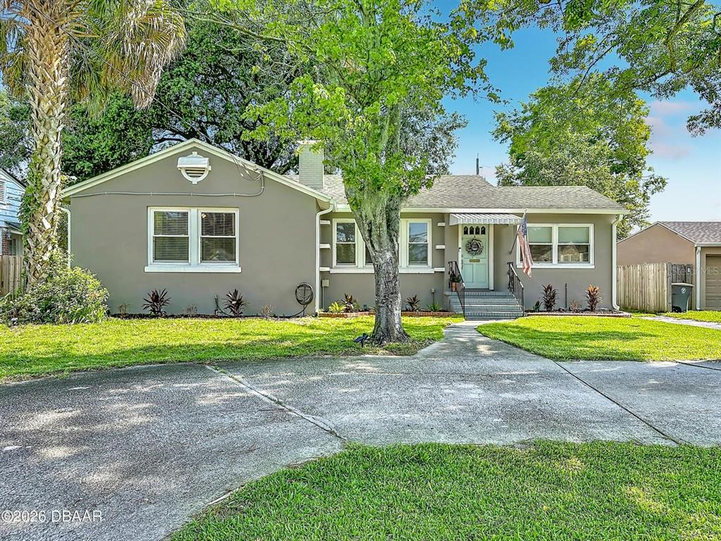 A single-story house with gray stucco siding, a front walkway, and a large shade tree — 2615 RIDGEWOOD ROAD, JACKSONVILLE, FL