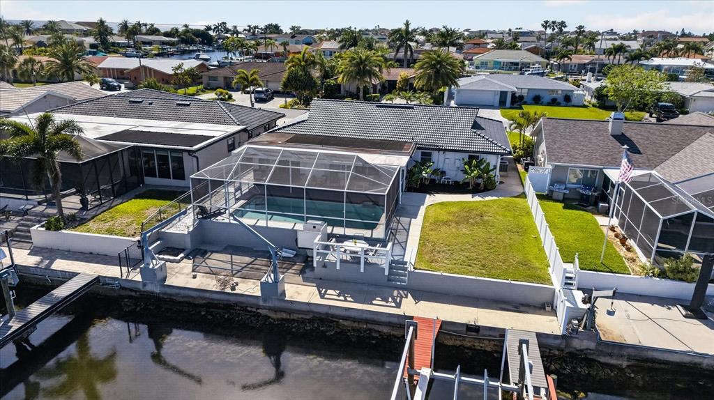 An aerial view of a waterfront house featuring a screened-in pool and a boat dock — 4980 GALLEON COURT, NEW PORT RICHEY, FL