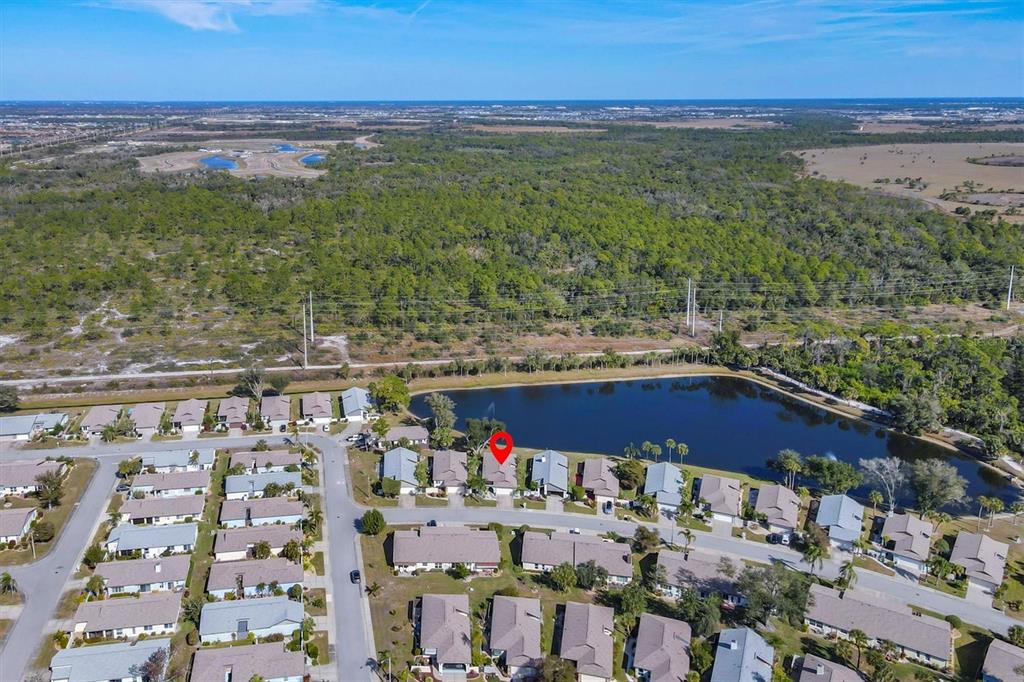 An aerial view shows a residential neighborhood with a lake and a marked house — 687 LINDEN DRIVE, ENGLEWOOD, FL