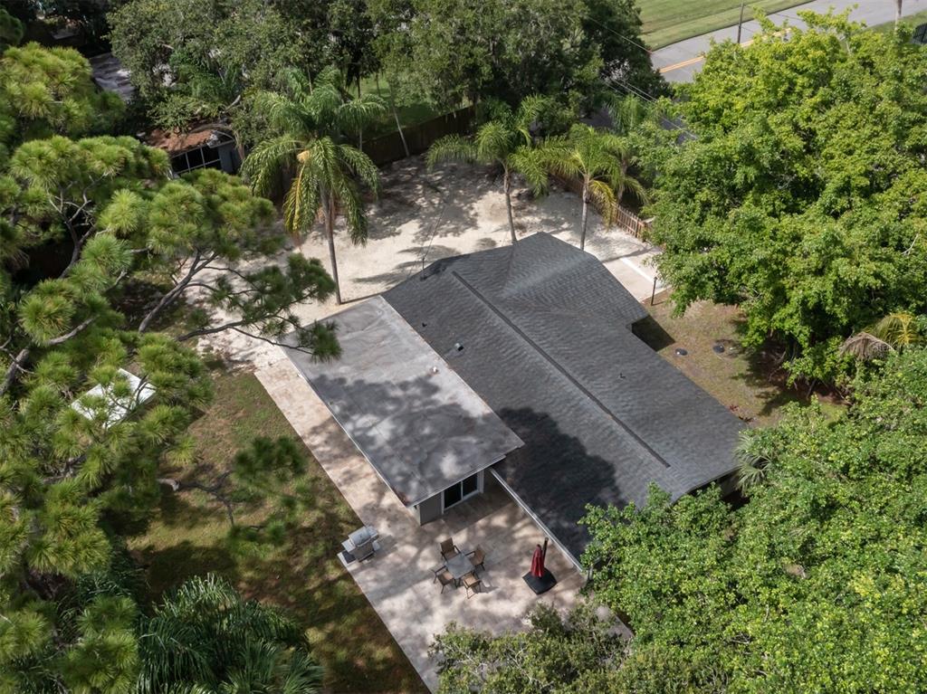 An aerial view shows a house with a shingled roof, a patio, and surrounding trees — 6115 CARLTON AVENUE, SARASOTA, FL