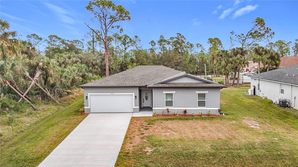 A single-story gray house with a white garage door and a concrete driveway — 2391 YANKEE TERRACE, NORTH PORT, FL