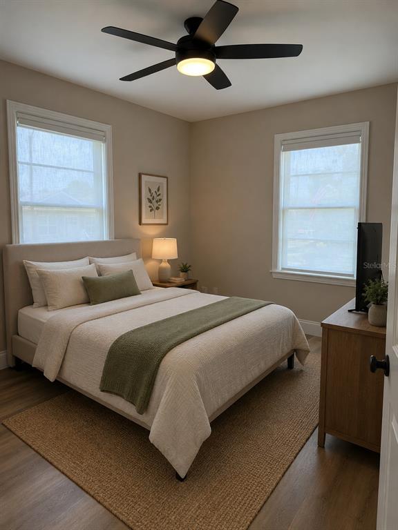A bedroom features a bed with a green runner, a ceiling fan, and two windows — 124 20TH AVENUE N, ST PETERSBURG, FL