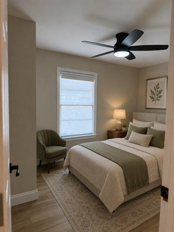 A bedroom features a bed with olive green accents, a matching armchair, and a ceiling fan — 124 20TH AVENUE N, ST PETERSBURG, FL