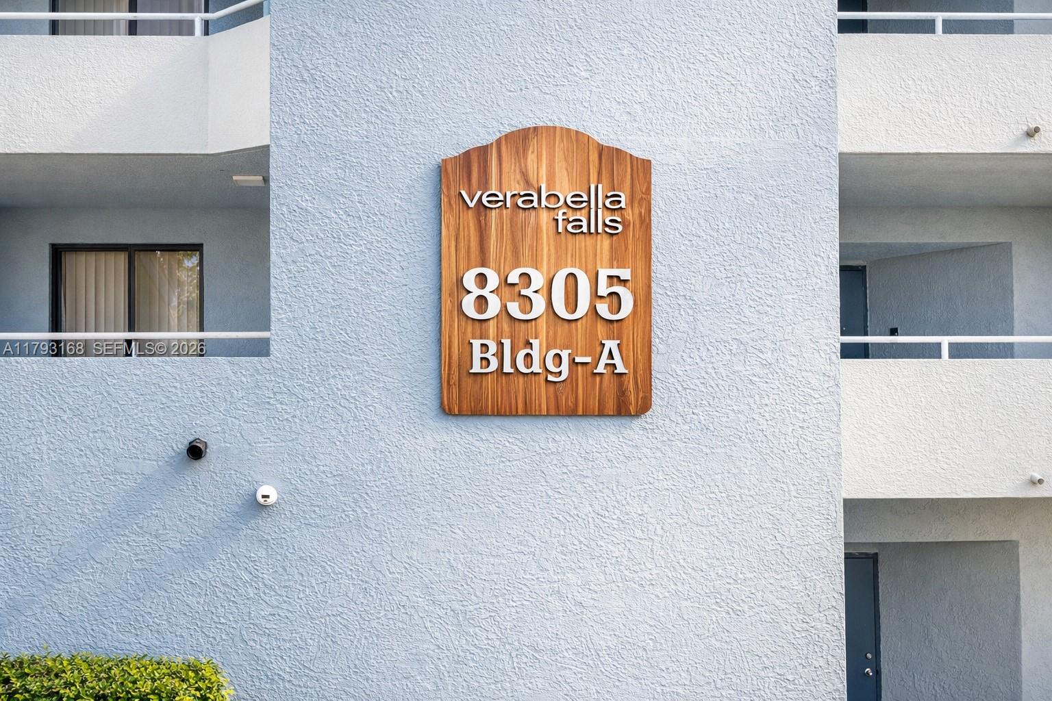 A wooden sign labeled Verabella Falls 8305 Bldg-A is mounted on a light blue exterior wall — 8305 SW 152nd Ave # 411, Miami FL 33193, MIAMI, FL
