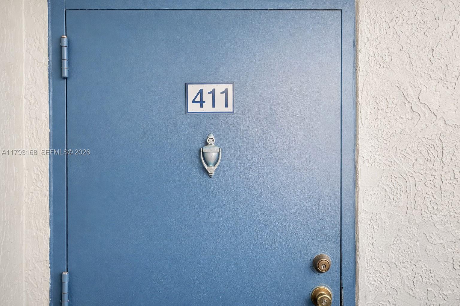 A blue apartment door features the number 411, a silver knocker, and two door locks — 8305 SW 152nd Ave # 411, Miami FL 33193, MIAMI, FL