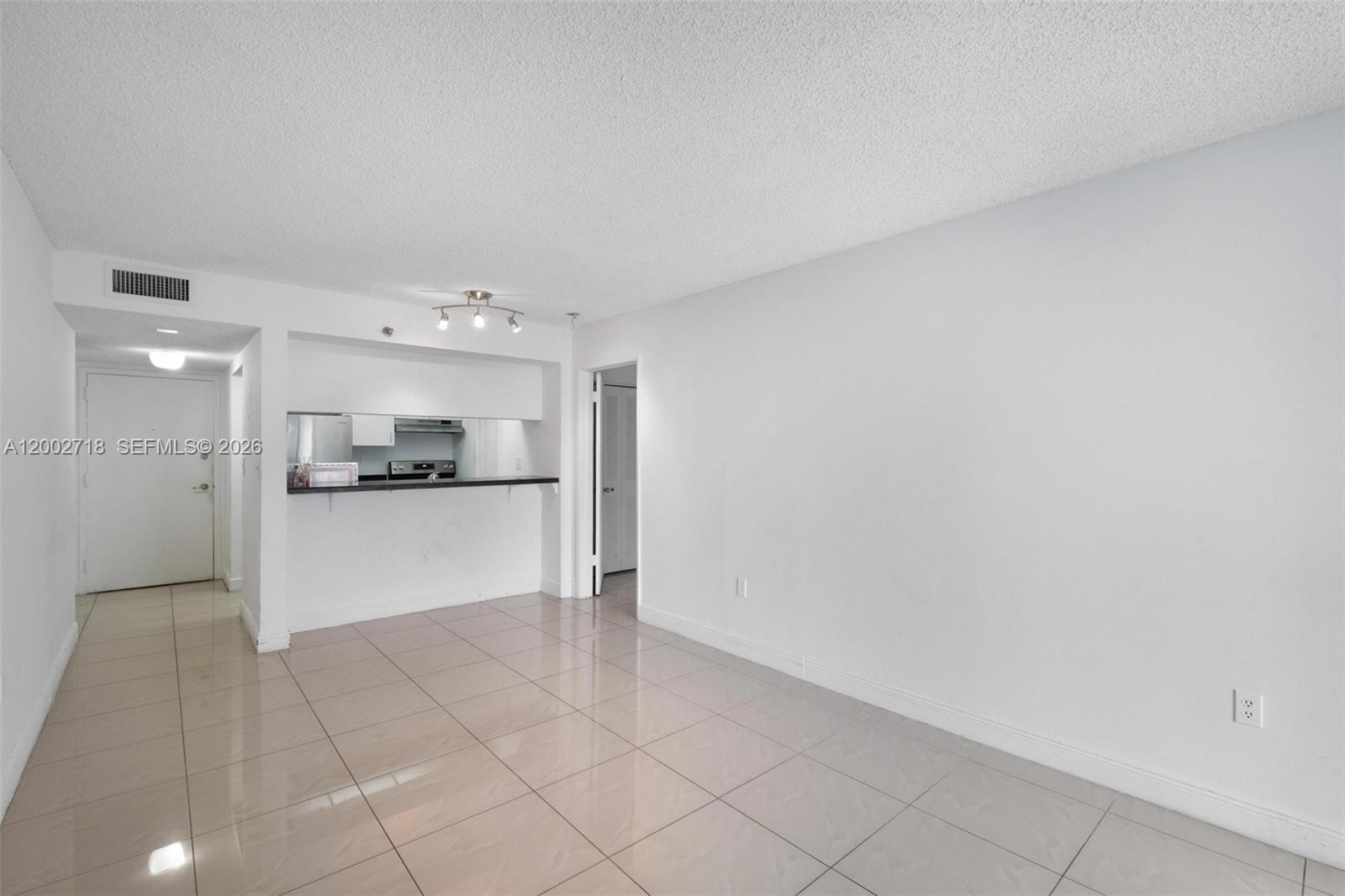 An interior view shows a living area with light-colored tile floors and a kitchen pass-through — 800 N Miami Ave # 1110, Miami FL 33136, MIAMI, FL