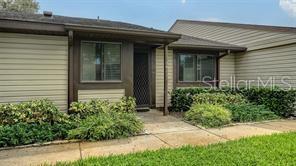 A single-story house with tan horizontal siding, a dark brown trim, and a front entryway — 5911 39TH AVENUE W, BRADENTON, FL