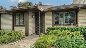 The exterior of a single-story house features beige siding, a covered entryway, and landscaped bushes — 5911 39TH AVENUE W, BRADENTON, FL