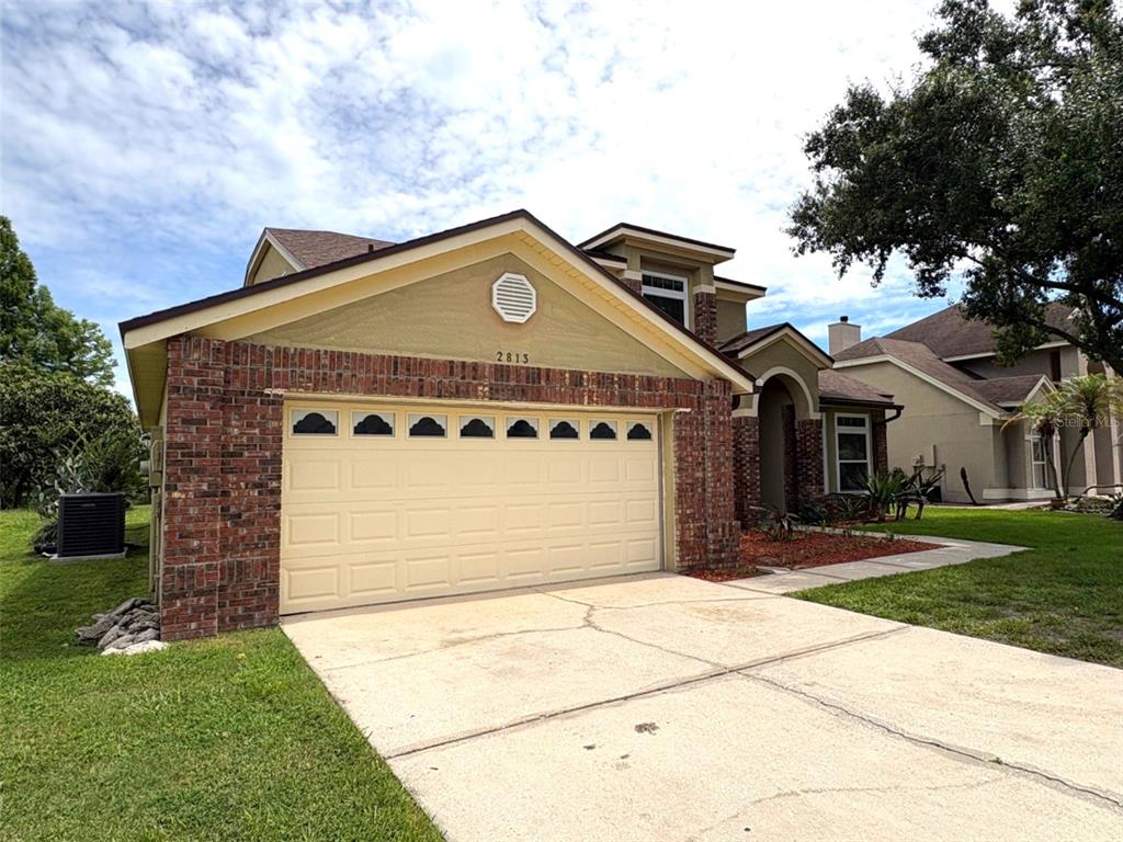 A two-story house with a brick and stucco exterior features a two-car garage — 2813 ROLLING BROAK DRIVE, ORLANDO, FL