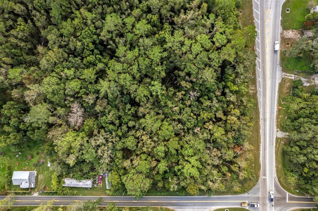 An aerial view shows a large, wooded lot bordered by two paved roads — 00 FORT DADE AVENUE, BROOKSVILLE, FL