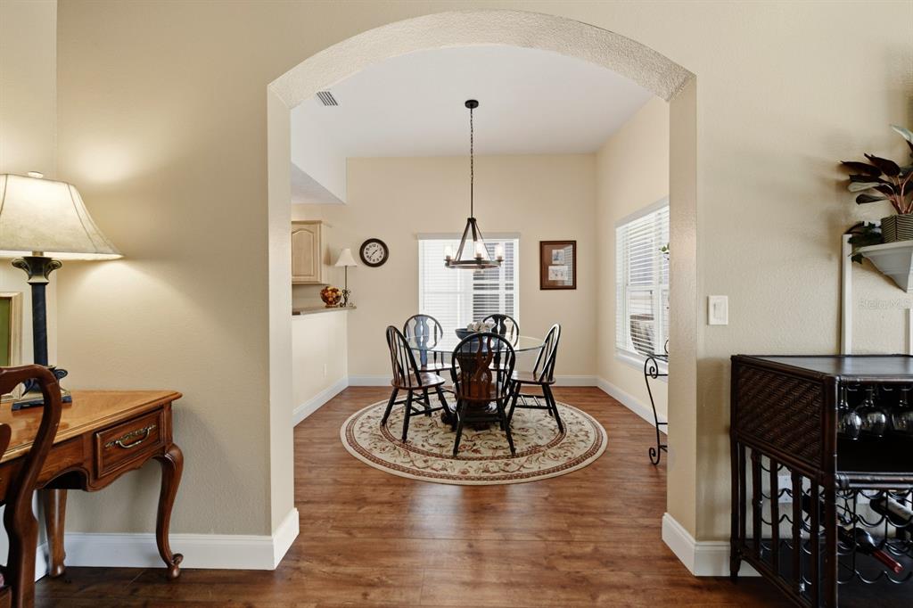 A dining area with a round table and chairs sits beyond an arched entryway — 1750 STAFFORD SPRINGS BOULEVARD, MOUNT DORA, FL