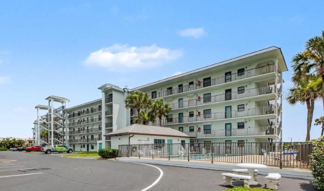 A multi-story apartment building with exterior balconies and a ground-level swimming pool — 3180 OCEAN SHORE BOULEVARD UNIT 108, ORMOND BEACH, FL