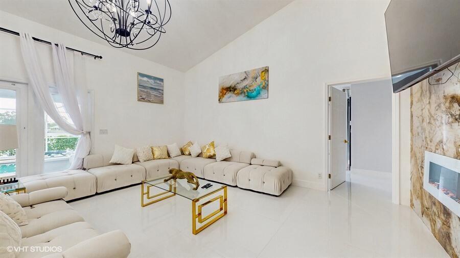 A living room features white modular seating, a glass coffee table, and a fireplace wall — 13646 Callington Drive, Wellington FL 33414, WELLINGTON, FL