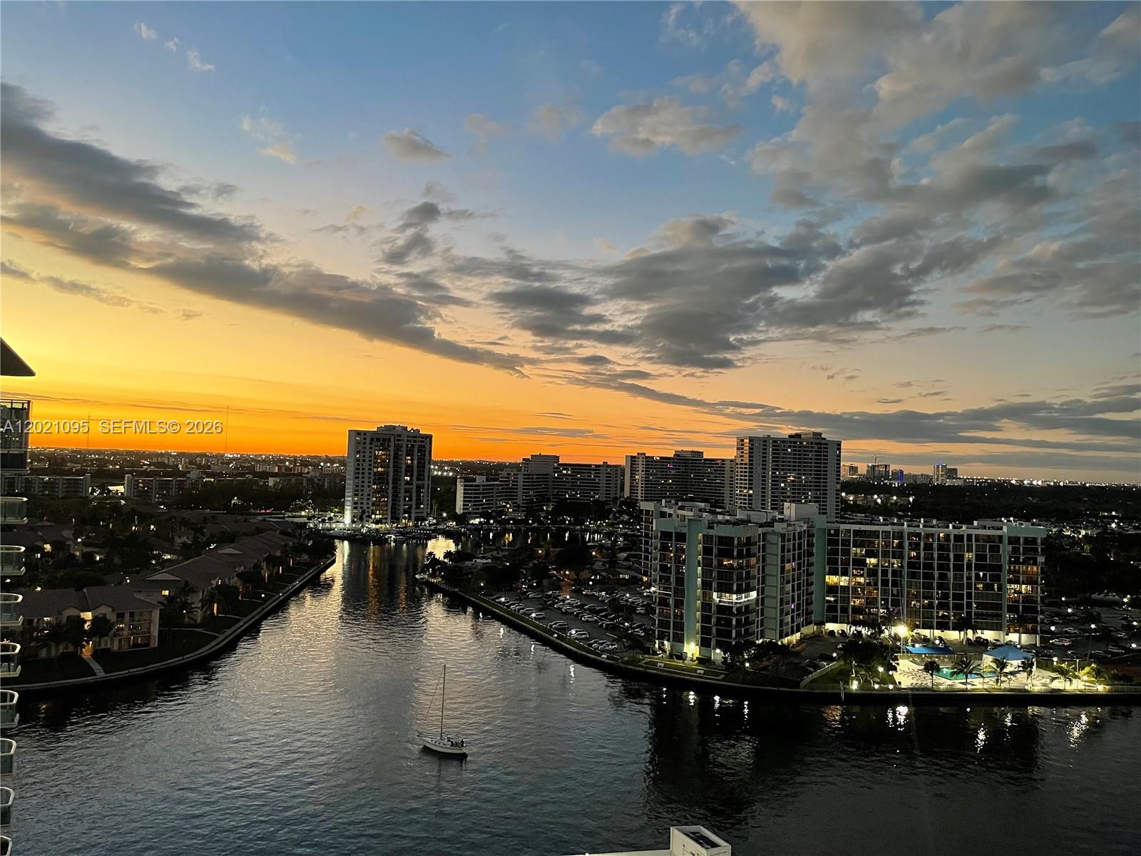 An elevated view of a sunset over a canal lined with apartment buildings and boats — 3800 S Ocean Dr # 1725, Hollywood FL 33019, HOLLYWOOD, FL