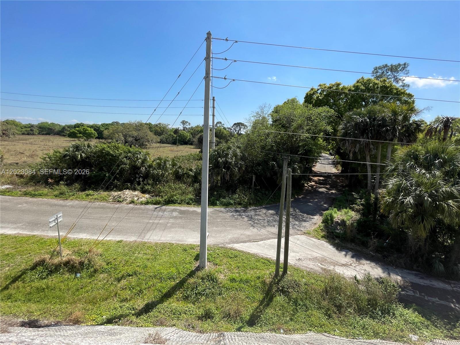 An elevated view shows a paved road intersection bordered by trees, grass, and utility poles — 2358 E SR 70, Okeechobee FL 34972, OKEECHOBEE, FL
