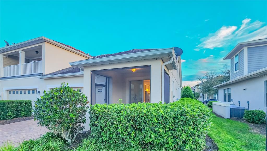 A screened-in patio is attached to the side of a two-story residential building — 2945 CELLO LANE, KISSIMMEE, FL