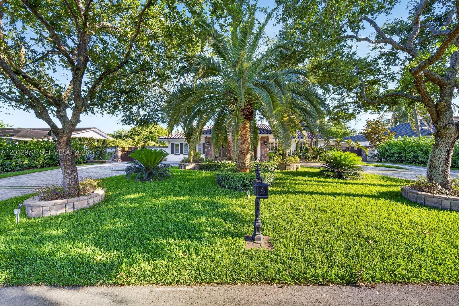 A palm tree stands in the front yard of a house with a paved driveway — 10570 SW 56th Ter, Miami FL 33173, MIAMI, FL