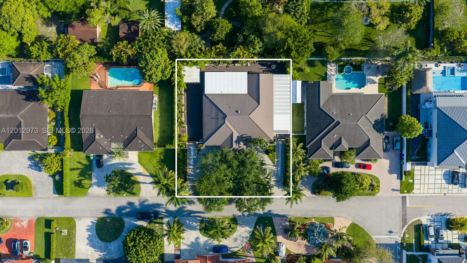An aerial view shows a residential house with a tiled roof, pool, and surrounding landscaping — 10570 SW 56th Ter, Miami FL 33173, MIAMI, FL