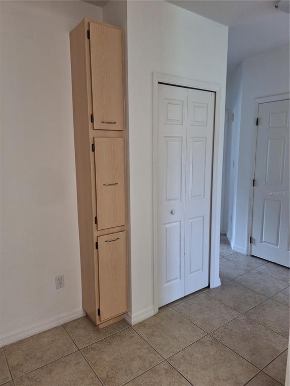 A kitchen corner features a white refrigerator, light wood cabinets with a brown countertop, and a window — 495 LAS CORTES LANE UNIT 201, ORLANDO, FL