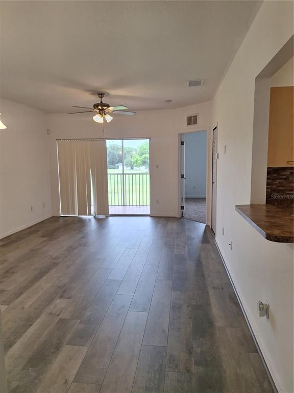 A tall light-wood cabinet stands next to a white bi-fold closet door in a tiled hallway — 495 LAS CORTES LANE UNIT 201, ORLANDO, FL