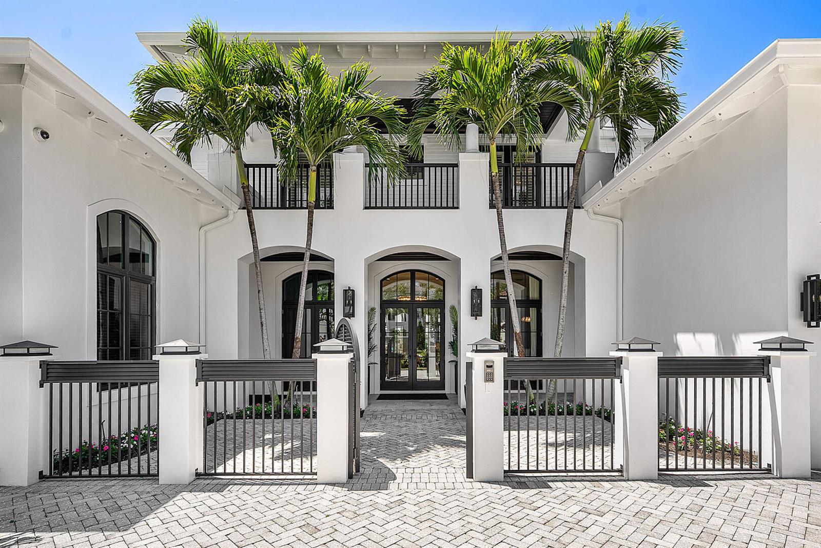 The exterior of a white two-story house features a gated courtyard and palm trees — 1720 Sabal Palm Drive, Boca Raton FL 33432, BOCA RATON, FL