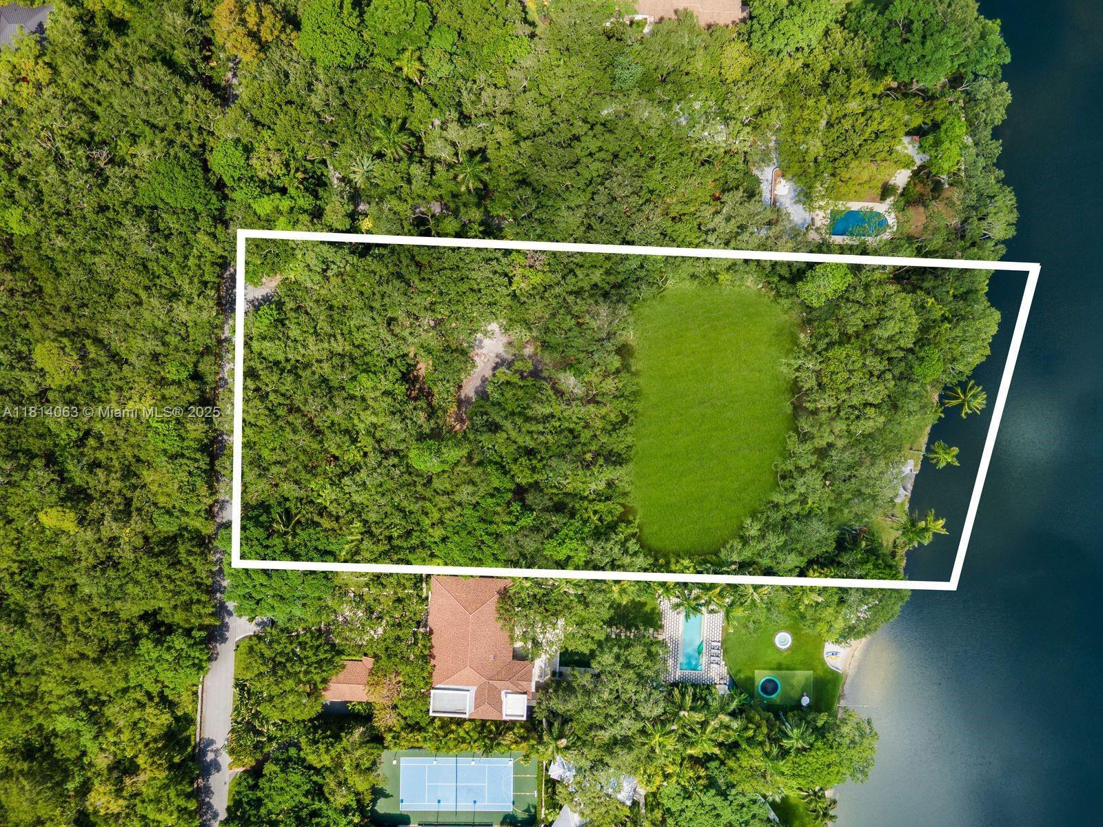 An aerial view shows a rectangular plot of land with a large grassy area — 5355 Hammock Dr, Coral Gables FL 33156, CORAL GABLES, FL