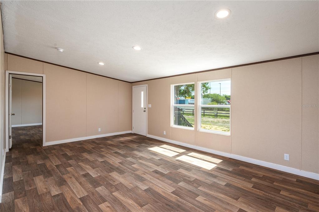 An empty room with beige walls, wood-look flooring, recessed lighting, and a white exterior door — 270 OLD BARTOW LAKE WALES, BARTOW, FL