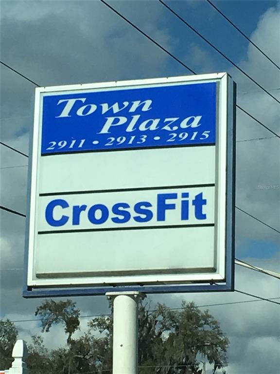 A rectangular sign for Town Plaza stands outdoors against a cloudy sky — 2911 NE JACKSONVILLE ROAD, OCALA, FL